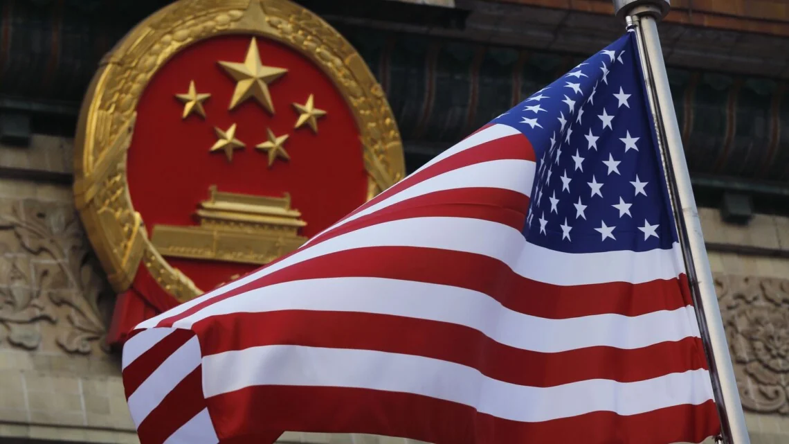 Прапор США майорить на тлі державного герба Китаю на фасаді