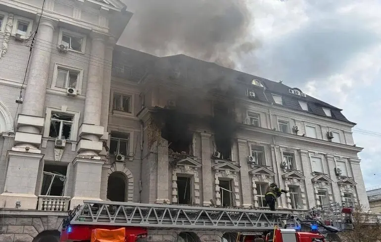 Пожежники на драбині гасять палаючу білу будівлю СБУ з густим димом