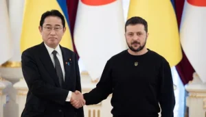 Зеленський і Кісіда тиснуть руки на тлі прапорів України та Японії