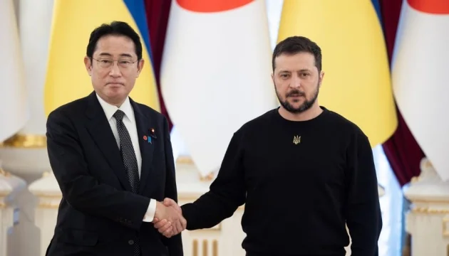 Зеленський і Кісіда тиснуть руки на тлі прапорів України та Японії