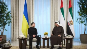 Зеленський і президент ОАЕ сидять на зустрічі біля прапорів України та Еміратів