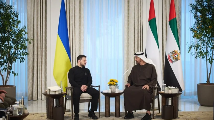 Зеленський і президент ОАЕ сидять на зустрічі біля прапорів України та Еміратів