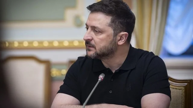 Зеленський розмовляє з людиною в офіційному кабінеті з гербом